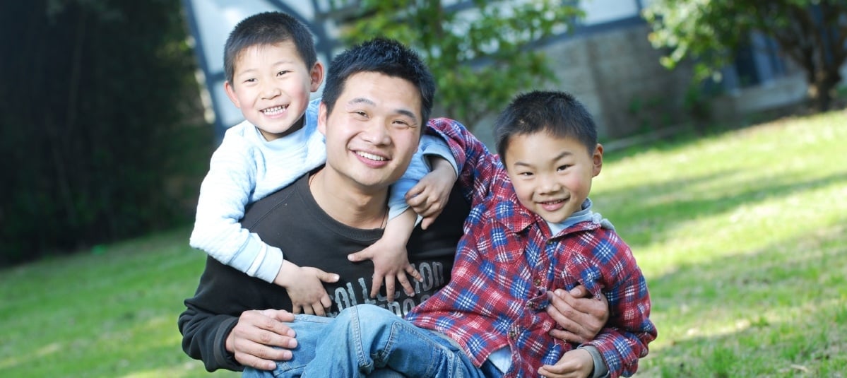 Asian dad playing with sons outside-773937-edited.jpg